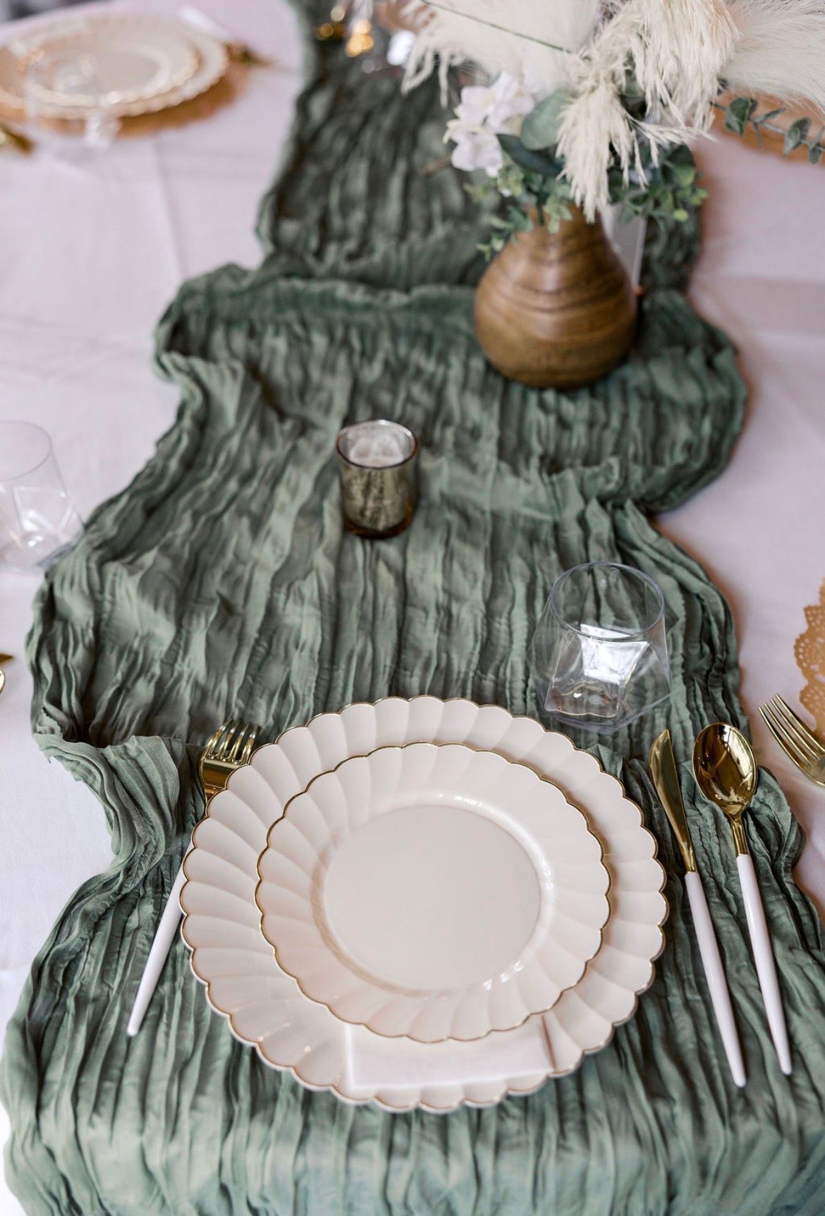 Elegant banquet table with white linens, floral centerpiece, candles, and place settings by a window