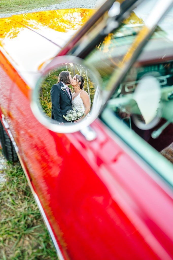 Wedding couple walking through flower confetti tunnel outdoors