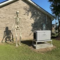 Skeleton decoration beside a white cabinet on a lawn next to a brick house