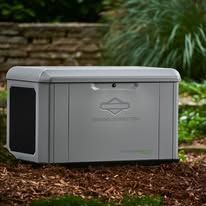 Gray outdoor storage box on mulch in a garden, with stone wall and greenery behind it