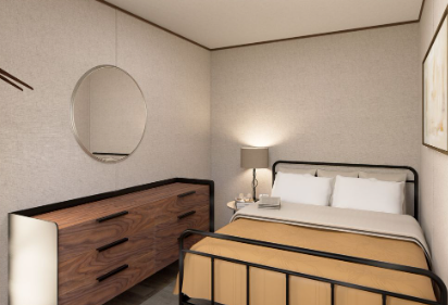 Small bedroom with a wooden dresser, round mirror, and bed with white bedding and a tan blanket.