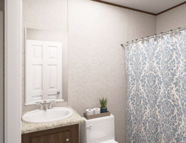 Small bathroom with sink, toilet, mirror cabinet, and blue patterned shower curtain.