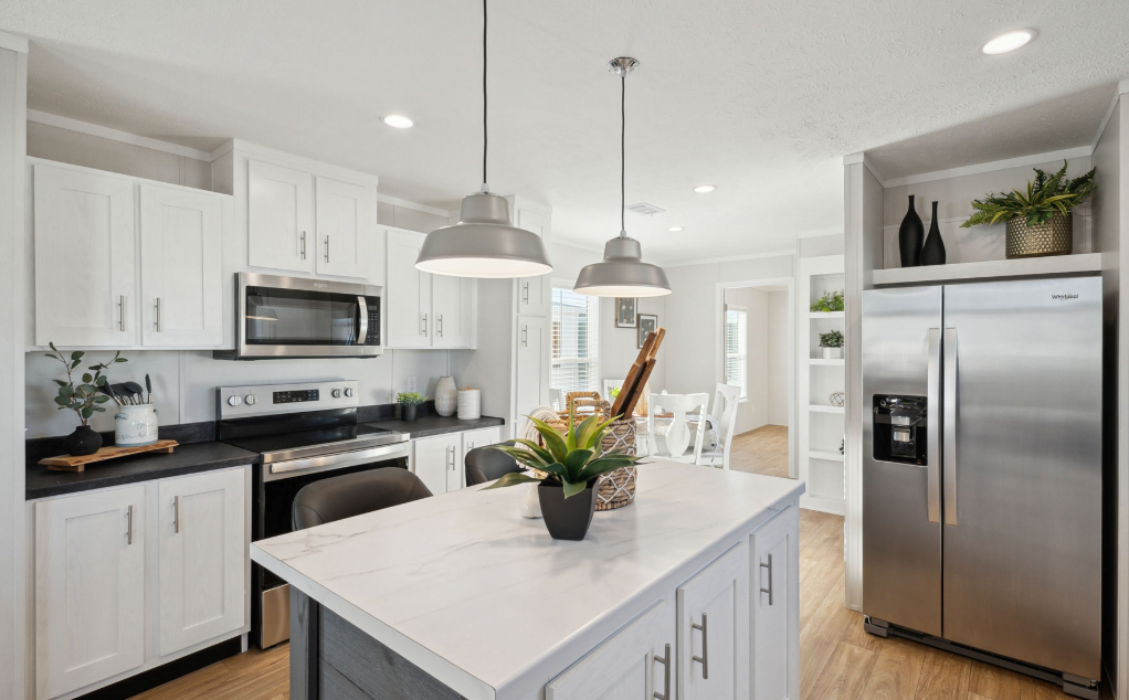 Bright modern kitchen with white cabinets, stainless appliances, and a central island with flowers