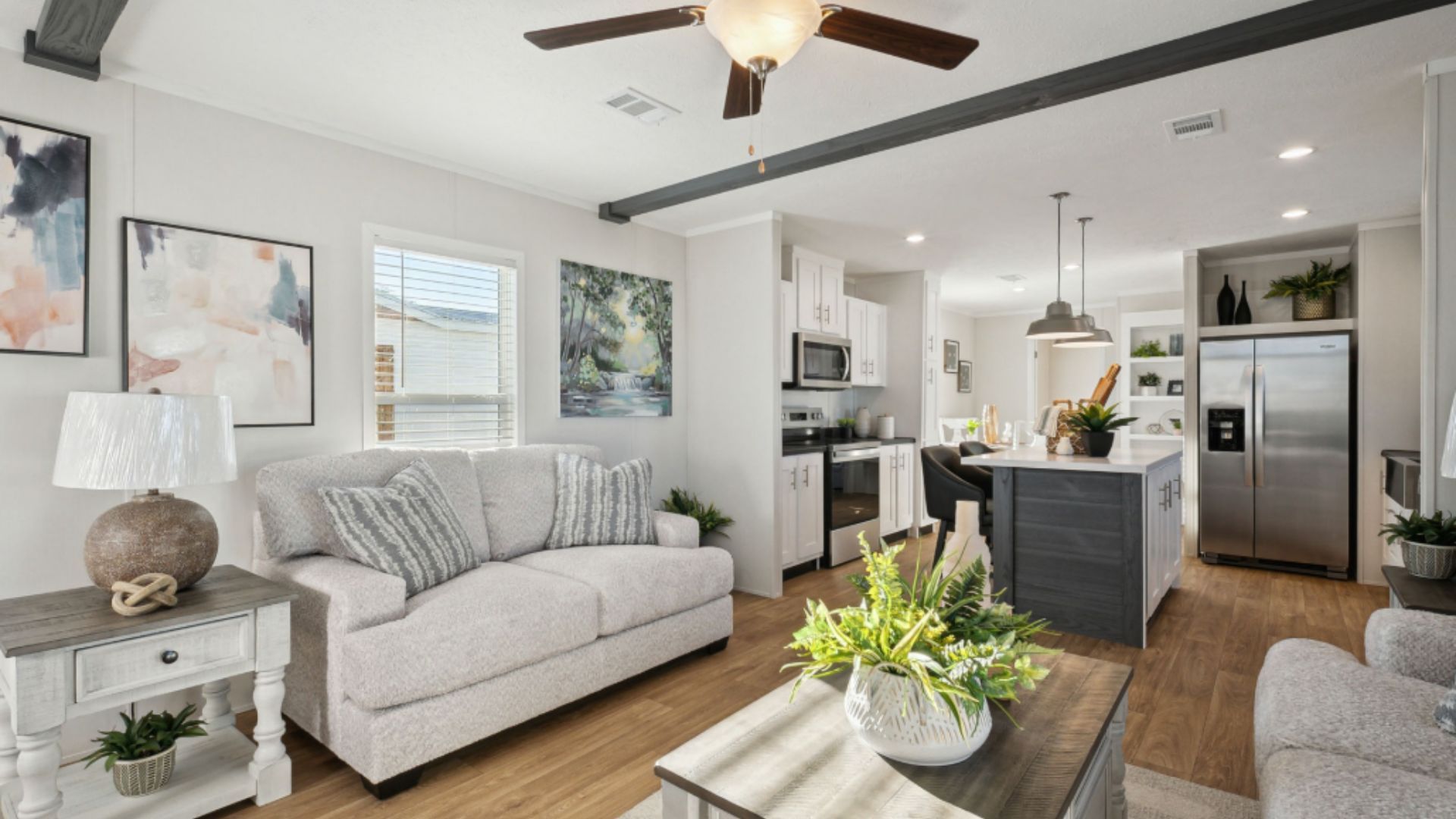 Modern living room with white sofa, black lounge chair, rug, and floor-to-ceiling curtains
