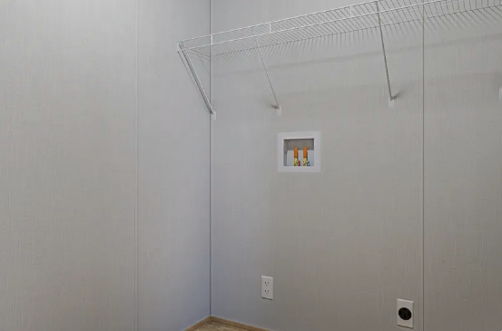 Empty white closet with wire shelving and a small wall opening