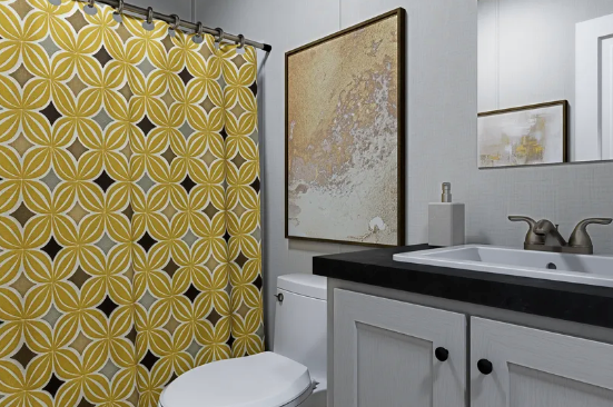 Yellow patterned shower curtain in a small bathroom with white vanity and black countertop.