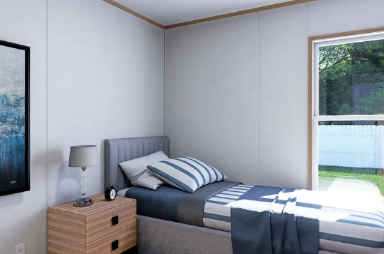 Minimal bedroom with gray bed, striped pillows, wood nightstand, and bright window.
