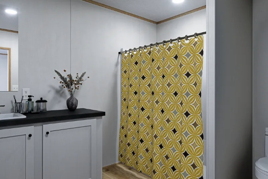 Bathroom with a yellow patterned shower curtain, gray walls, and a black countertop with a vase