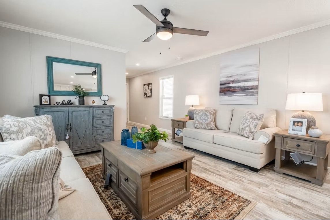 Living room with neutral tones, two sofas, coffee table, and blue accents.