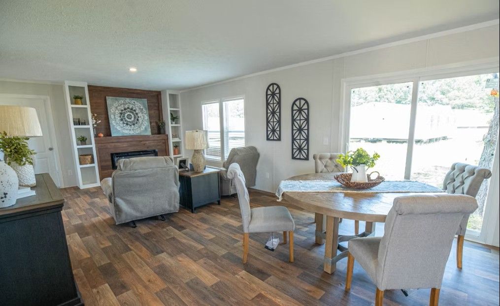Living room with fireplace, built-in shelves, dining area with round table, and a sliding glass door.