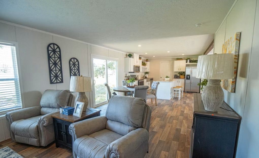 Spacious living room with recliners, table, and view into the open kitchen.