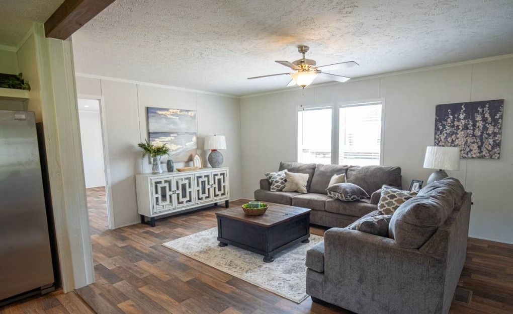 Living room with couch, coffee table, and decorative cabinet; neutral colors.