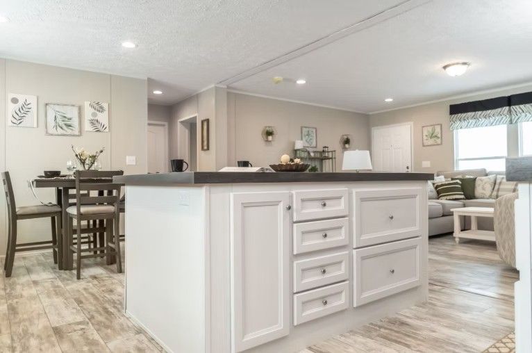 Kitchen island with drawers, dining table and living room visible in a modern home.