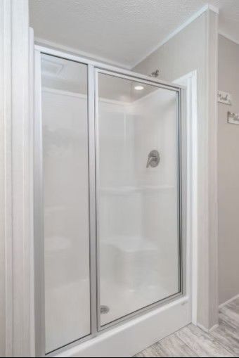 White shower stall with sliding glass doors in a bathroom.