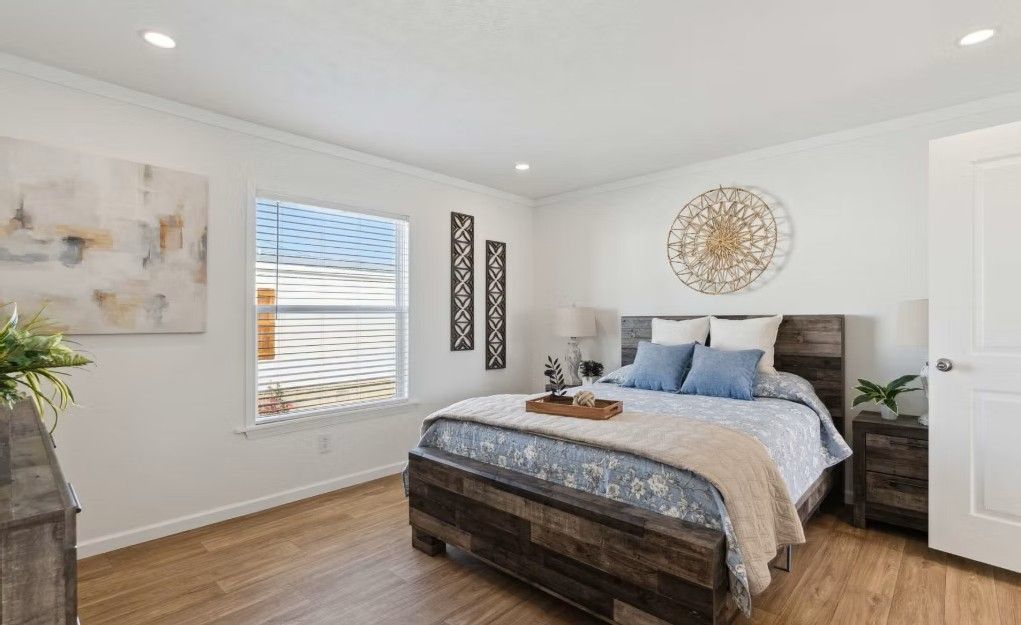 Bedroom with wood bed frame, white walls, and decorative accents.
