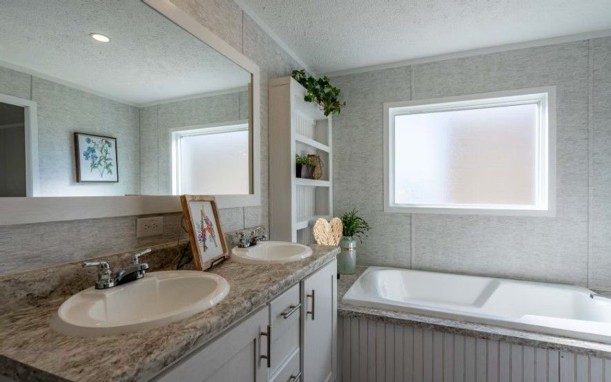 Bathroom with double sinks, tub, window, and built-in shelving; neutral tones.