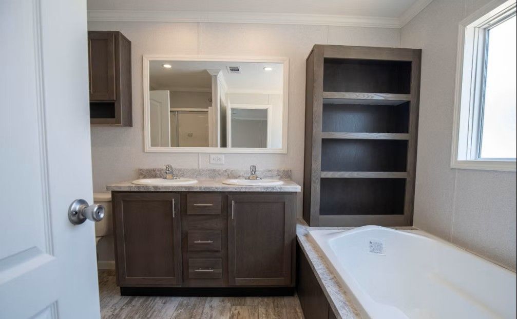 Bathroom interior with double vanity, mirror, tub, and shelving in neutral colors.