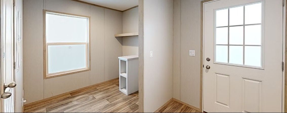 Interior view of a room with a window, cabinet, and white door.