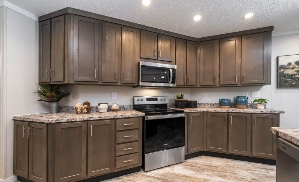 Kitchen with brown cabinets, stainless steel appliances, and granite countertops.