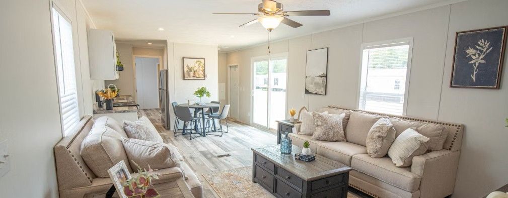 Spacious living room with beige sofas, wooden floor, and a dining area.