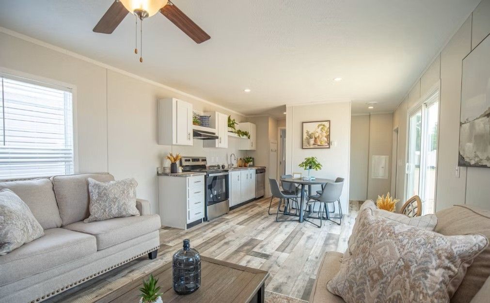 Open-concept living space with a kitchen, dining area, and living room. Neutral colors and wood-look flooring.