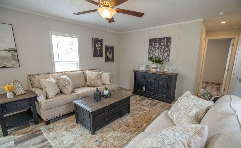 Living room with tan sofas, black furniture, and a rug.