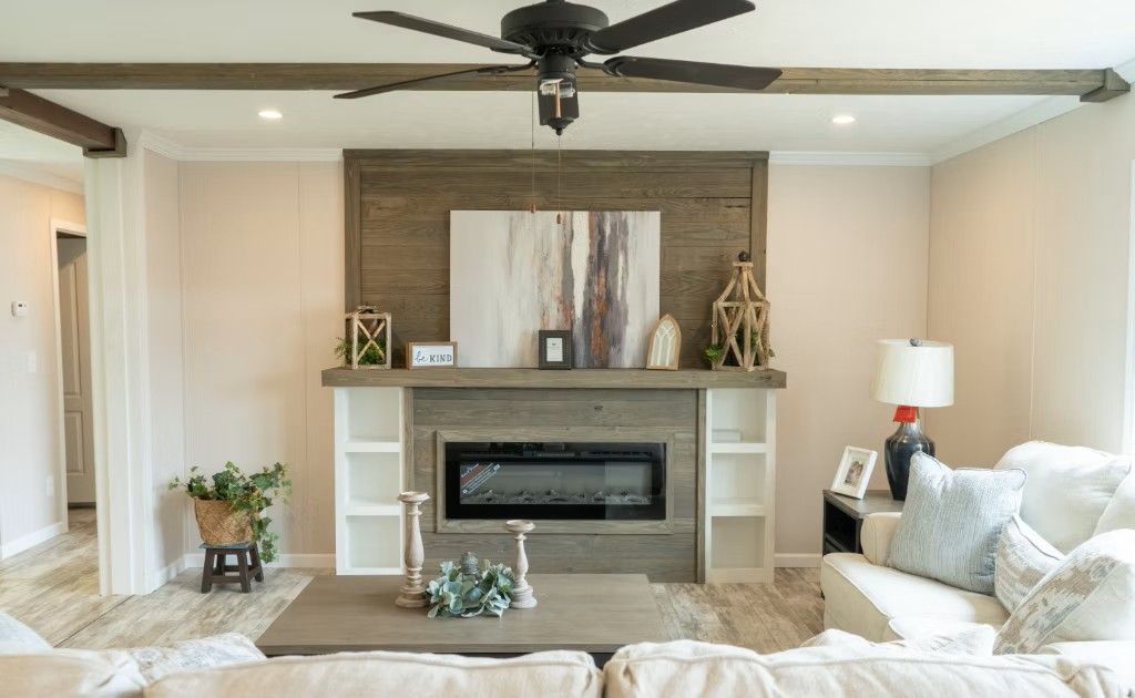 Living room with fireplace, white built-ins, and neutral-toned furniture. Brown accents include a ceiling fan.