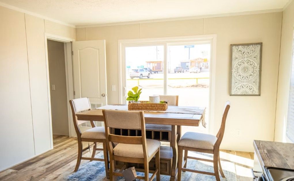 Dining room with a table, chairs, and a window. Beige walls and natural light.