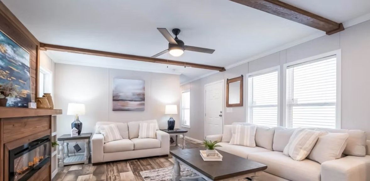 Living room with couches, fireplace, and window; neutral tones.
