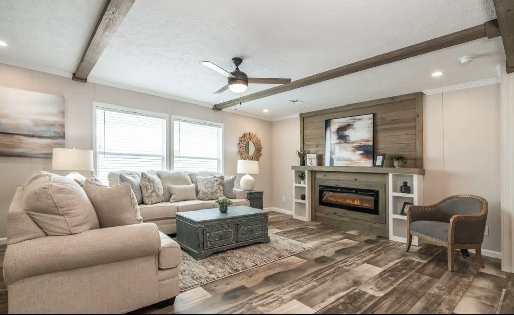 Living room with fireplace, sofa, accent chair, coffee table, wood beams, and textured flooring.