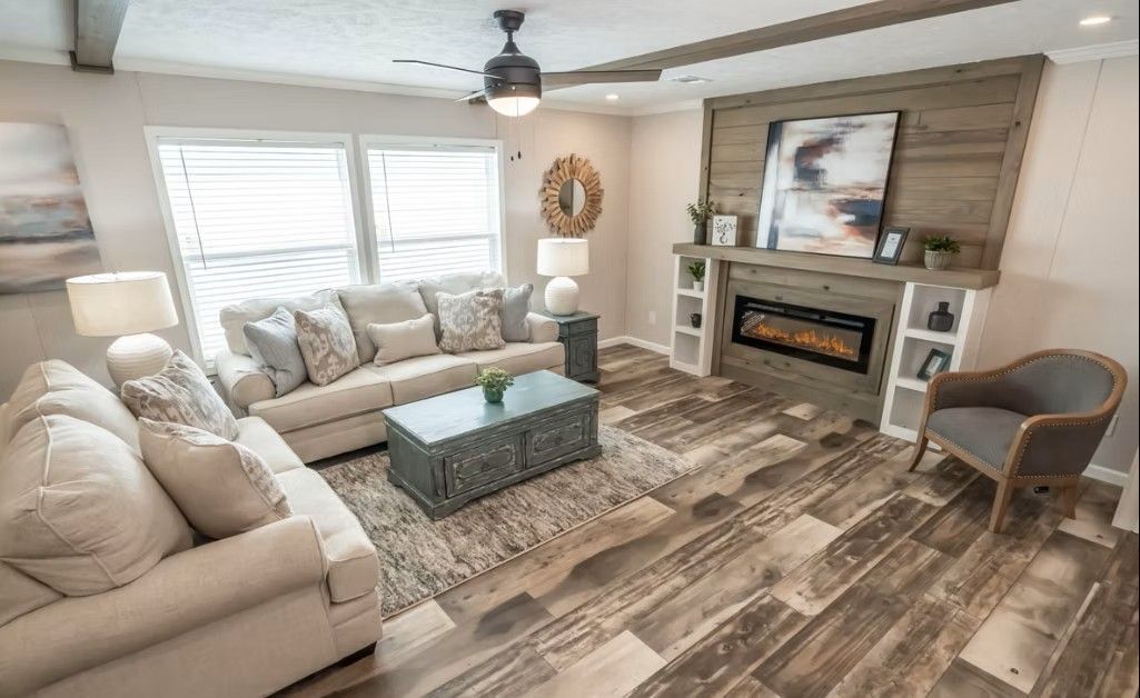 Living room with a fireplace, sofas, and wood-look flooring.