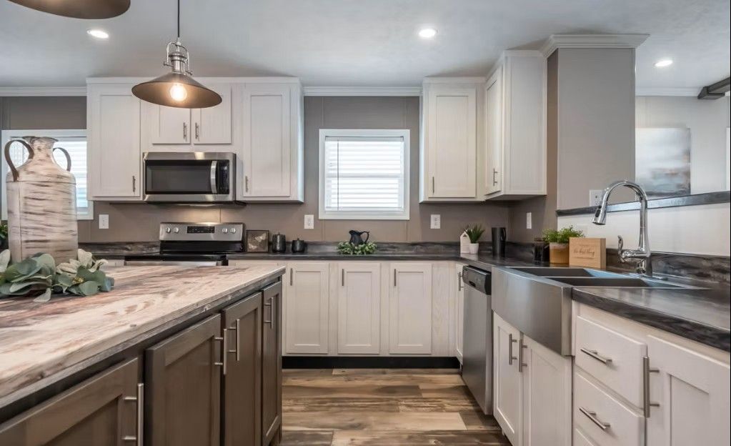 Modern kitchen with white and brown cabinets, stainless steel appliances, and a gray countertop.