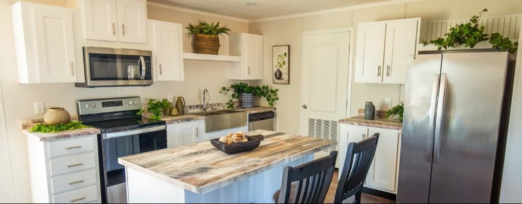 Kitchen with white cabinets, stainless steel appliances, and a wooden island.