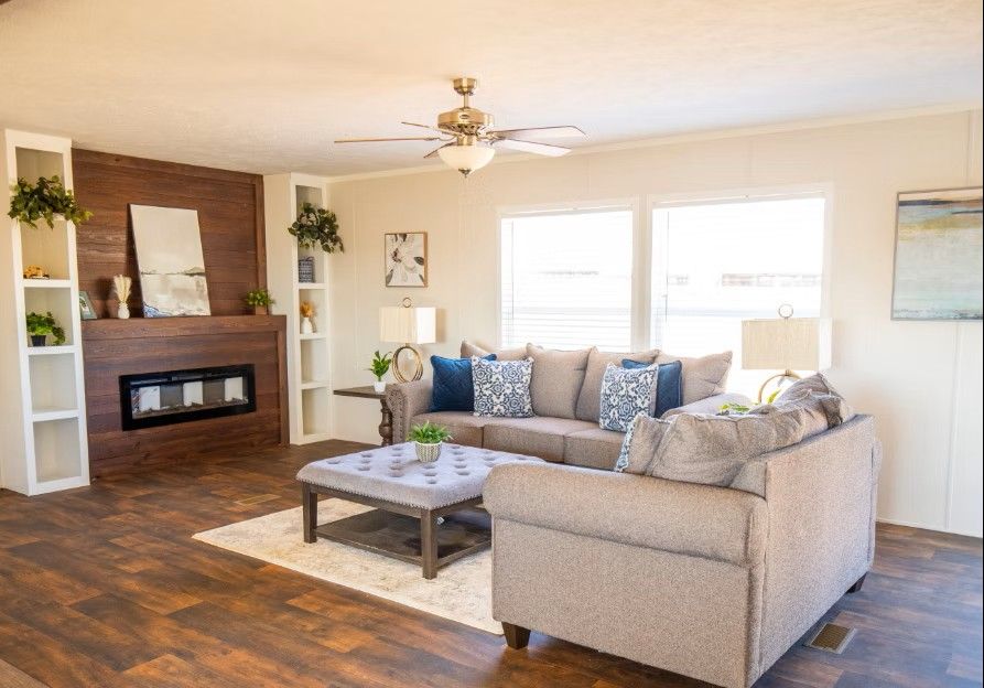 Living room with sofa, fireplace, and windows; neutral colors and contemporary style.
