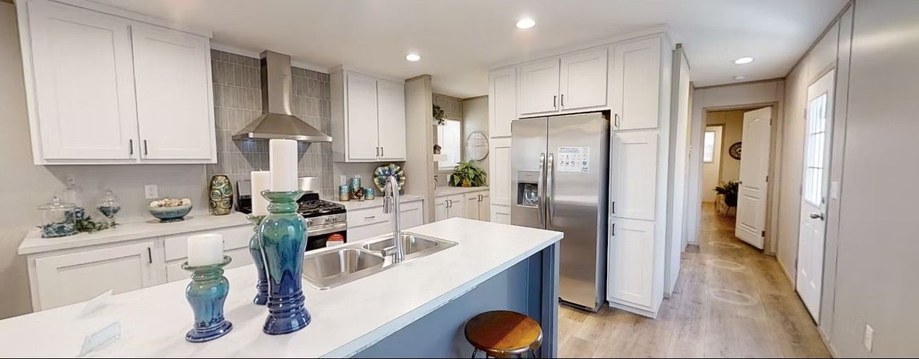 Modern kitchen with white cabinets, stainless steel appliances, and a central island.