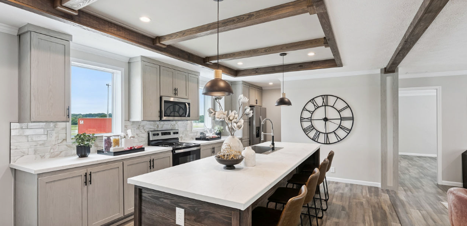 Bright modern kitchen with white cabinets, island, and large wall clock