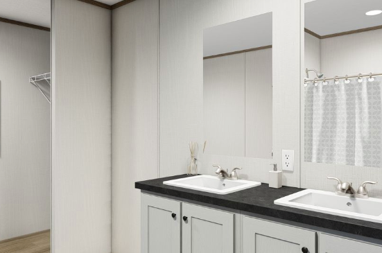 Modern bathroom vanity with double sinks, dark countertop, and large mirror in a bright white room