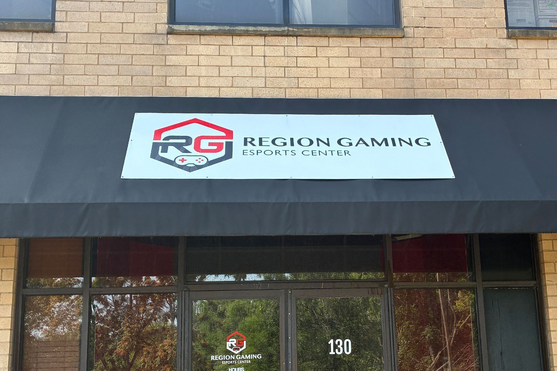 Region Gaming storefront sign on a black awning above glass doors
