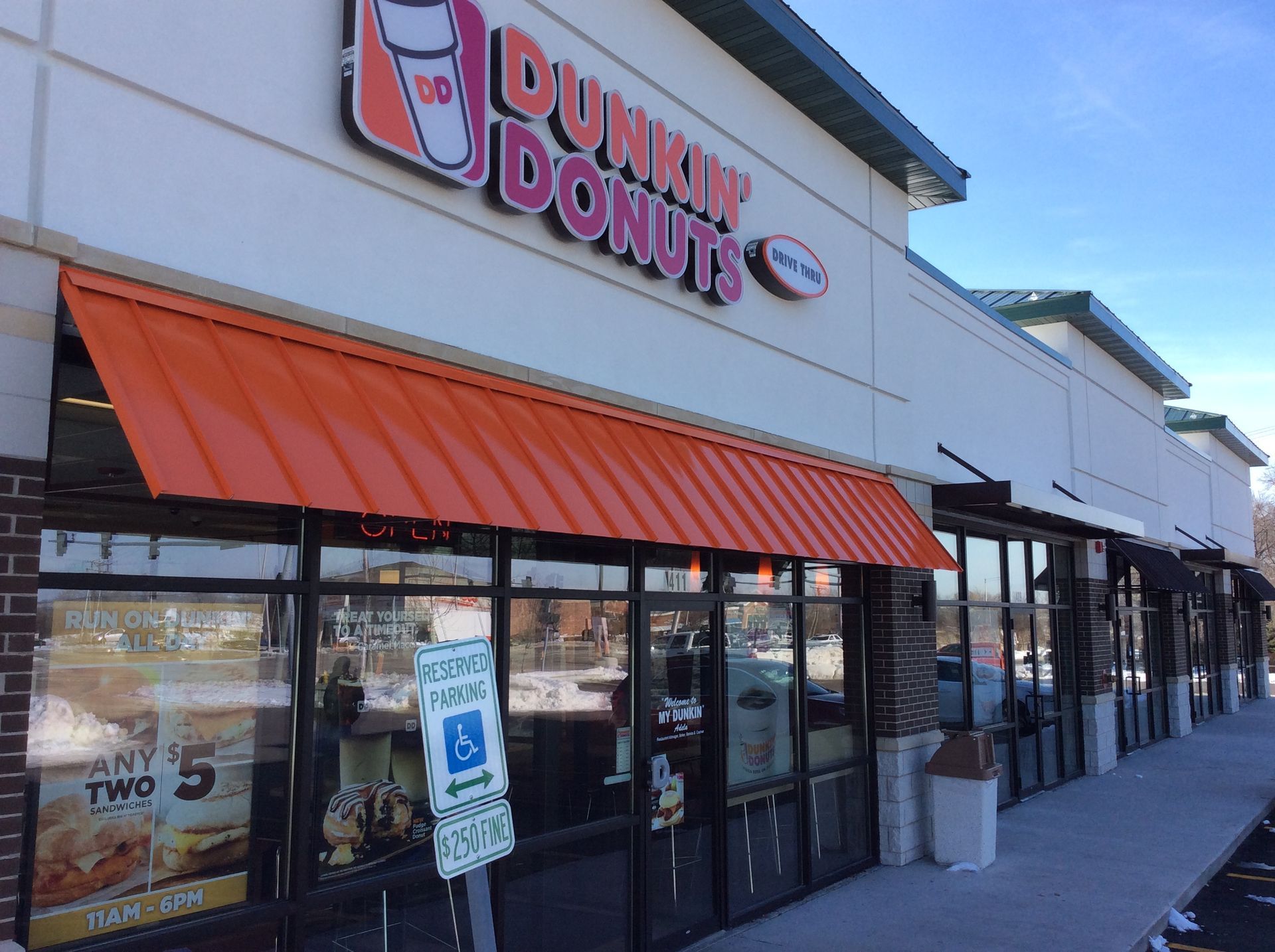 Dunkin’ Donuts storefront with orange awning and glass windows in a strip mall
