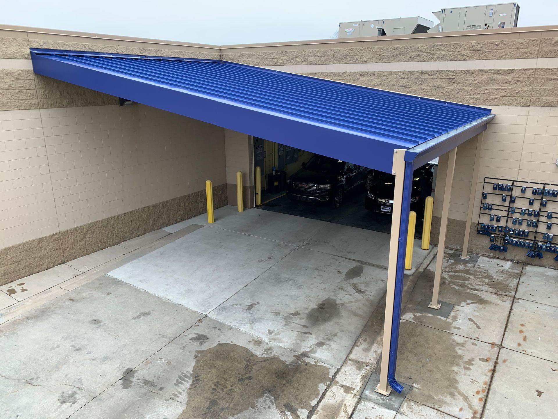Blue awning over a concrete loading dock entrance beside a beige building