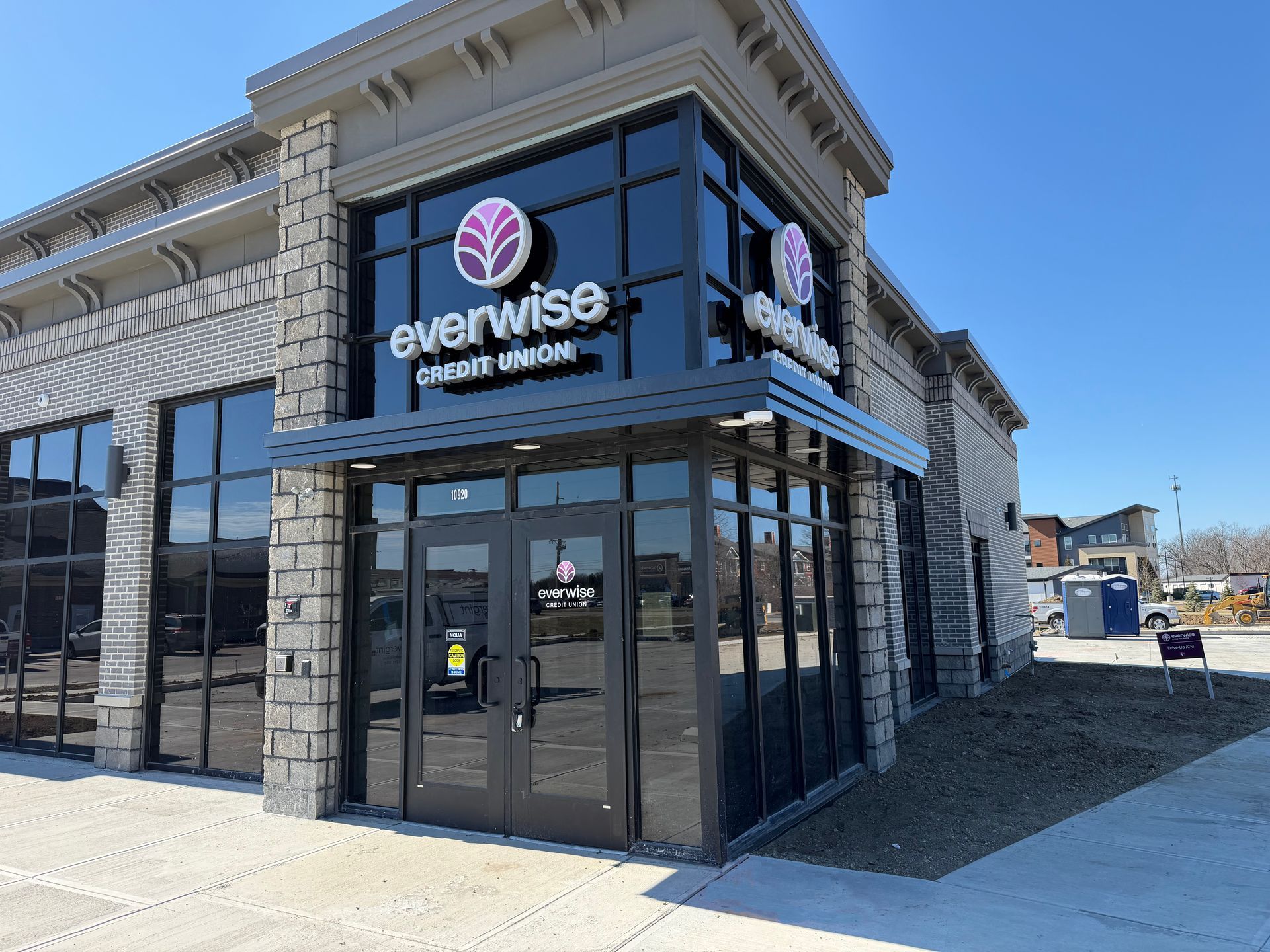 Exterior of the Evarise Center building with glass storefront and stone facade on a sunny day