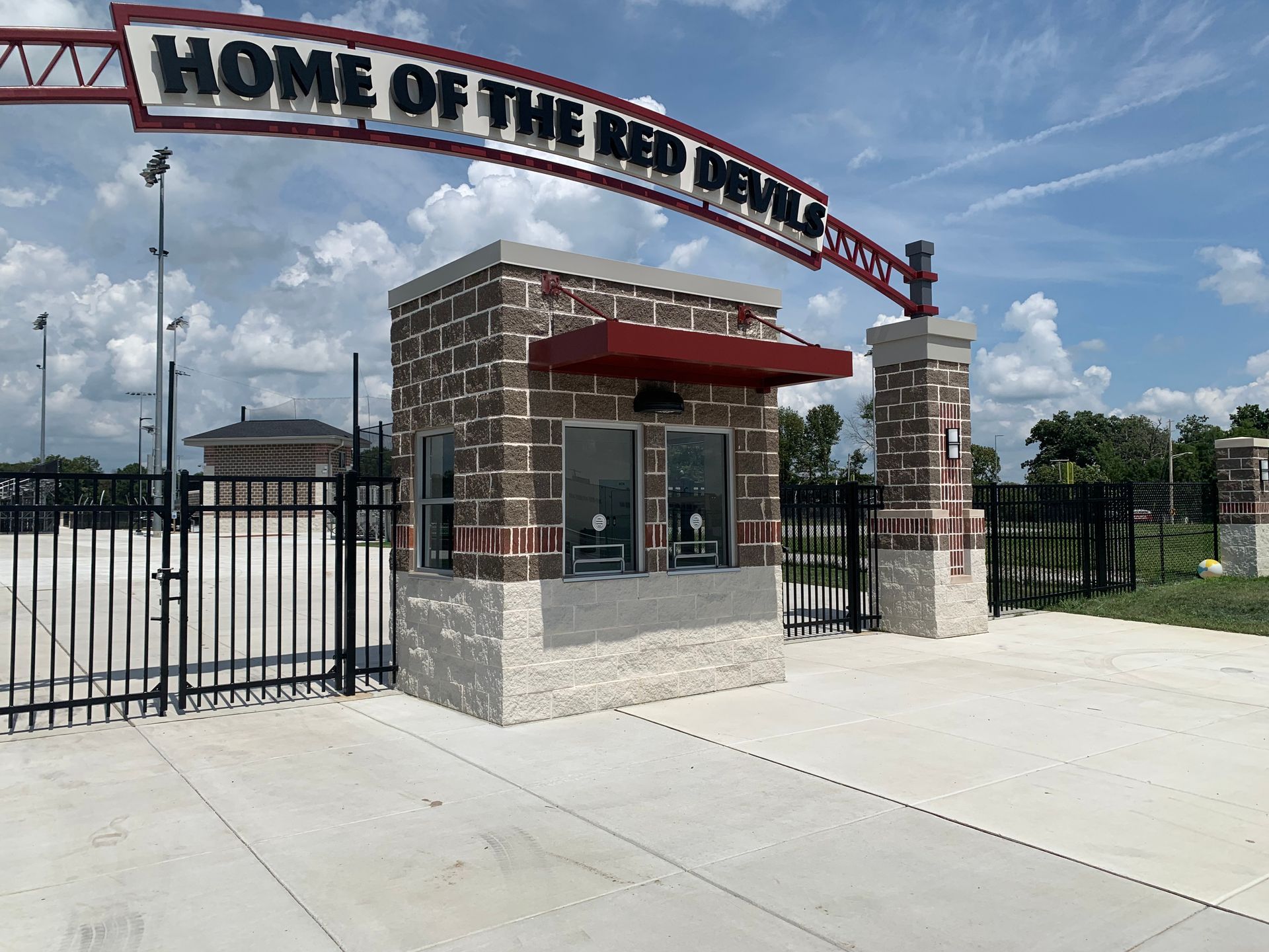 Red and white stadium entrance with a “Home of the Red Wave” archway and black metal gates
