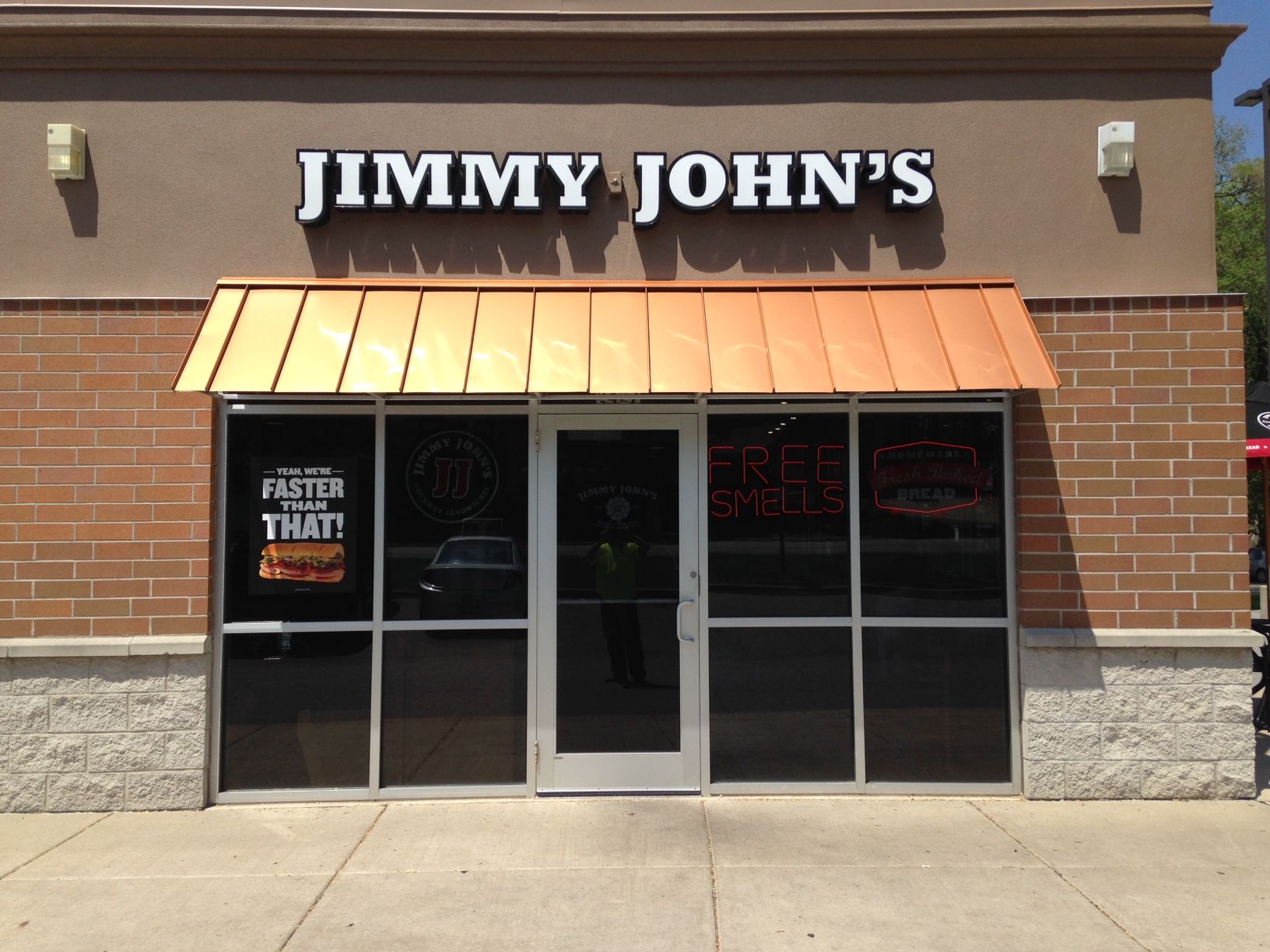 Jimmy John’s storefront with brown awning, glass doors, and brick exterior