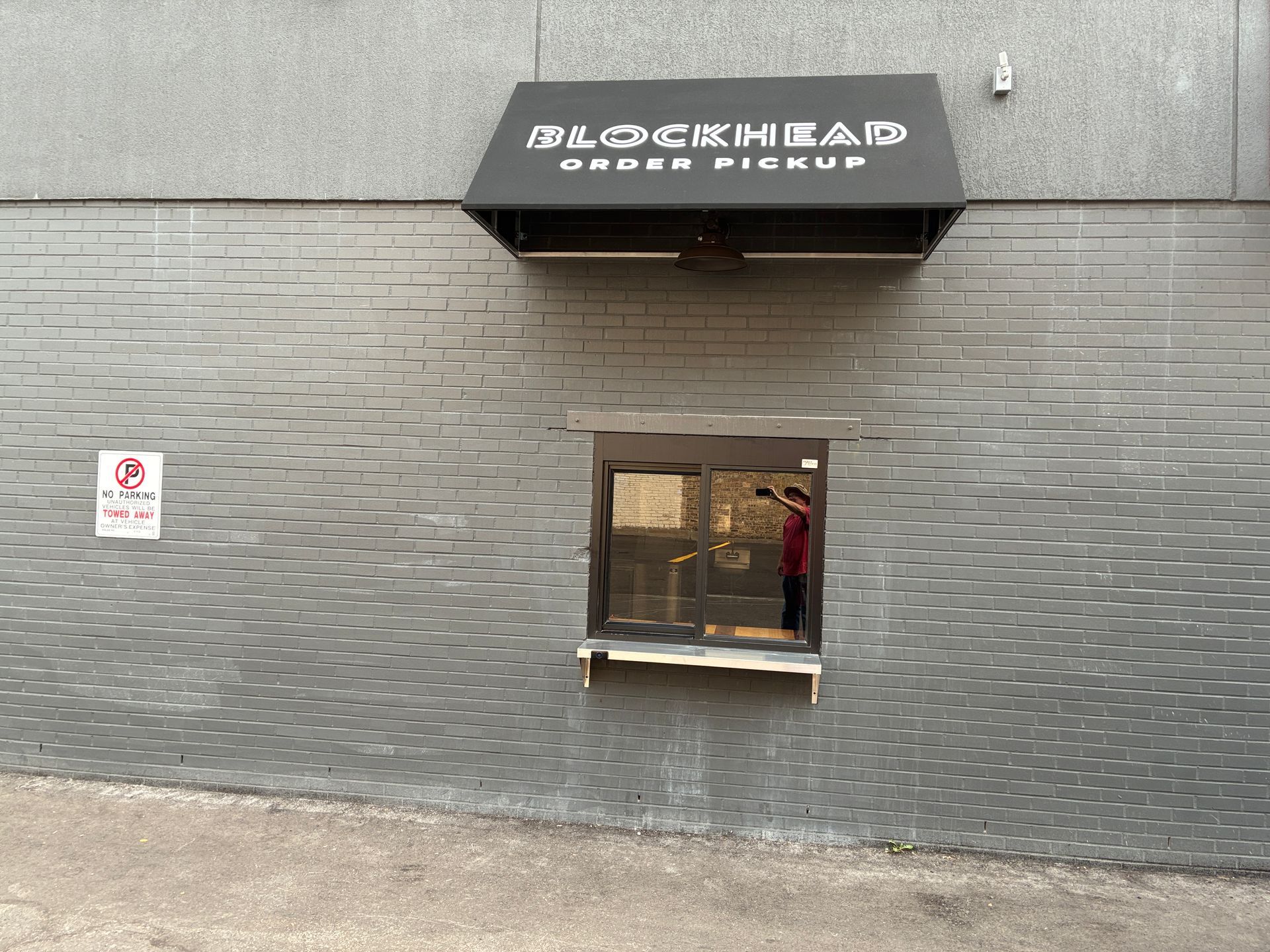 Black Sheep Hair Studio storefront with gray brick wall and a small window