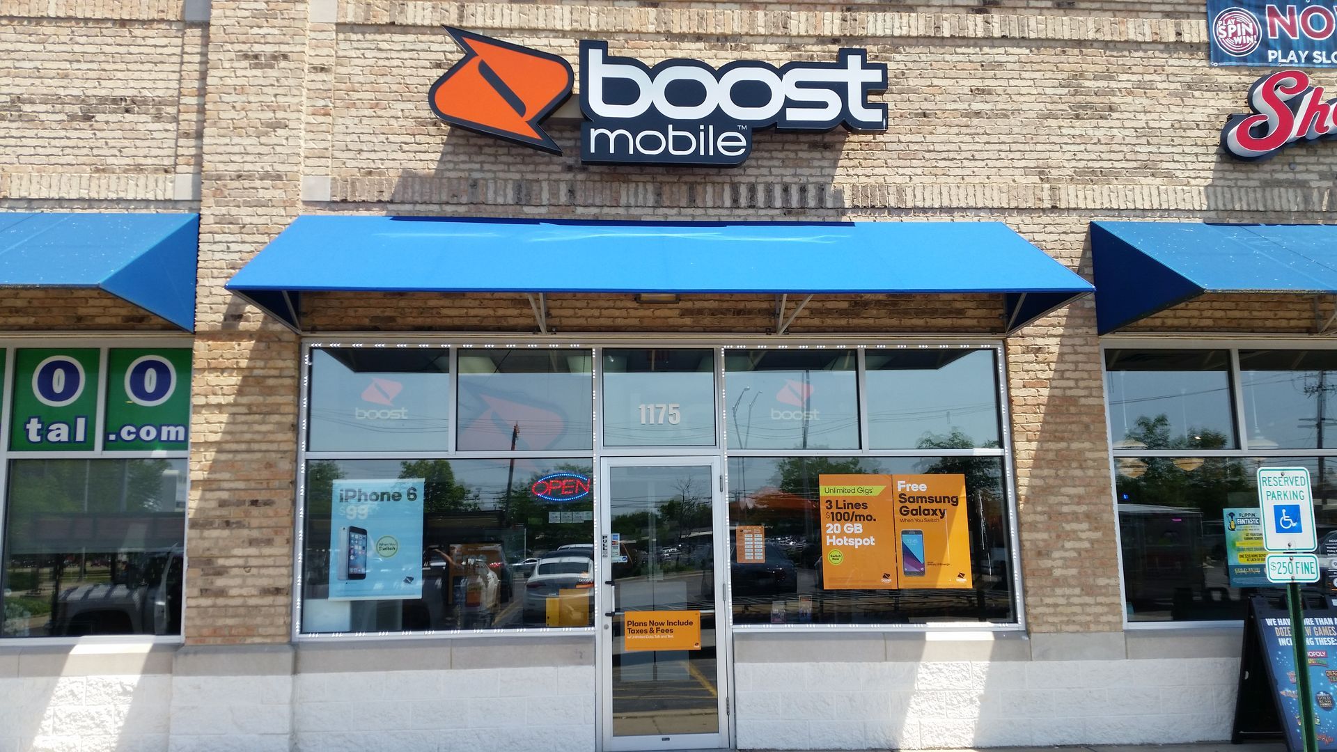 Boost Mobile storefront with blue awnings and glass windows in a strip mall.