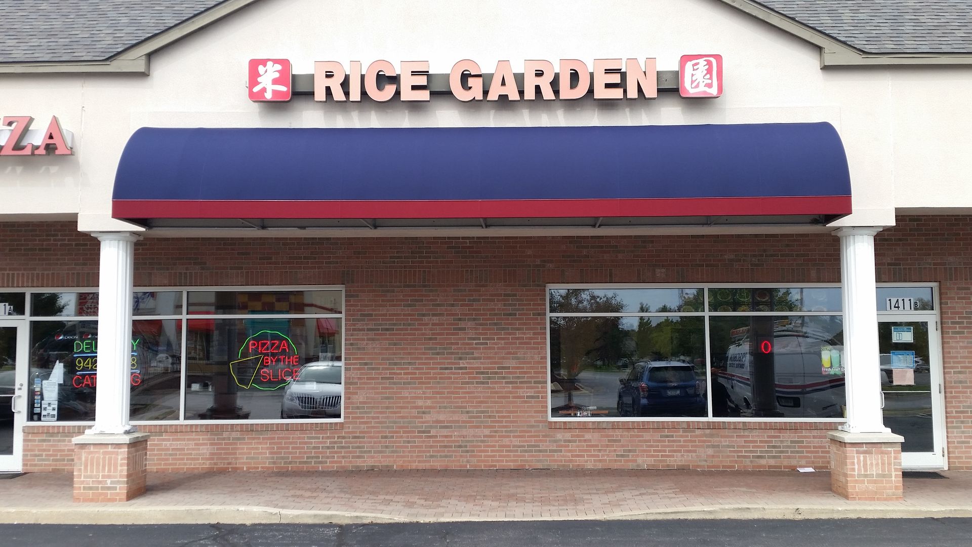 Rice Garden restaurant storefront with blue awning and brick facade