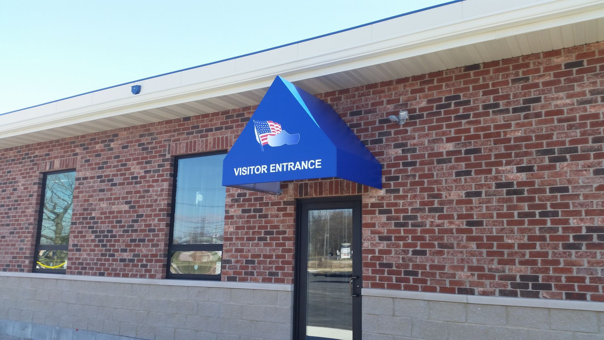 Brick storefront with blue awning over entrance, reading “Water Athletics”