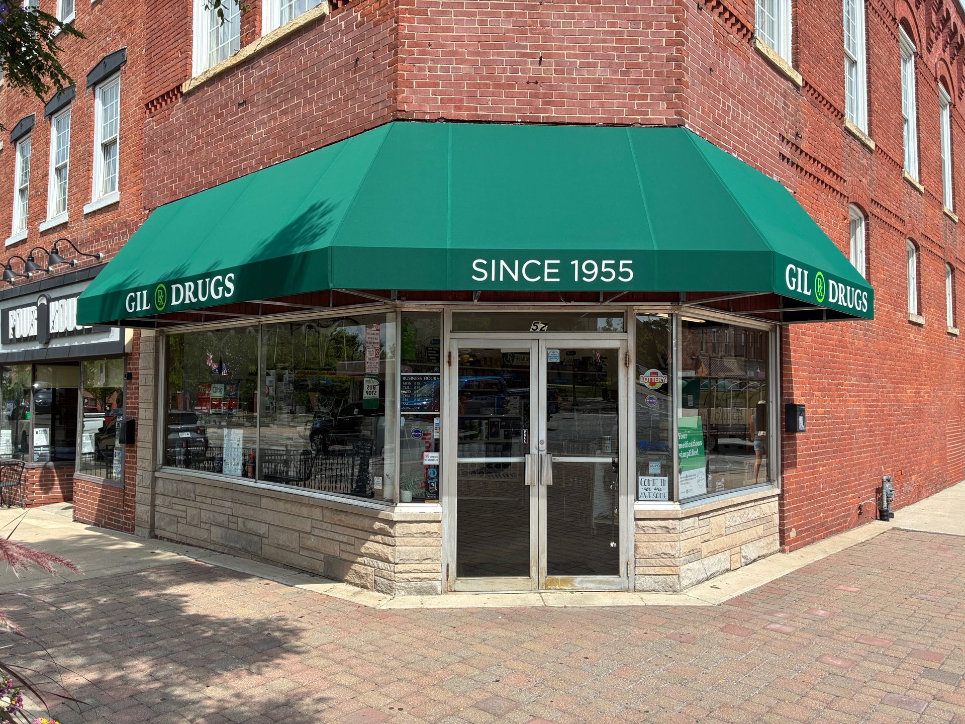 Corner storefront with green awning on a red brick building, marked “Since 1955.”