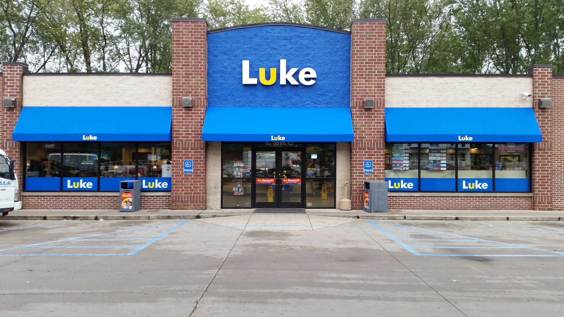 Storefront with blue awnings and a large “Luke” sign above the entrance