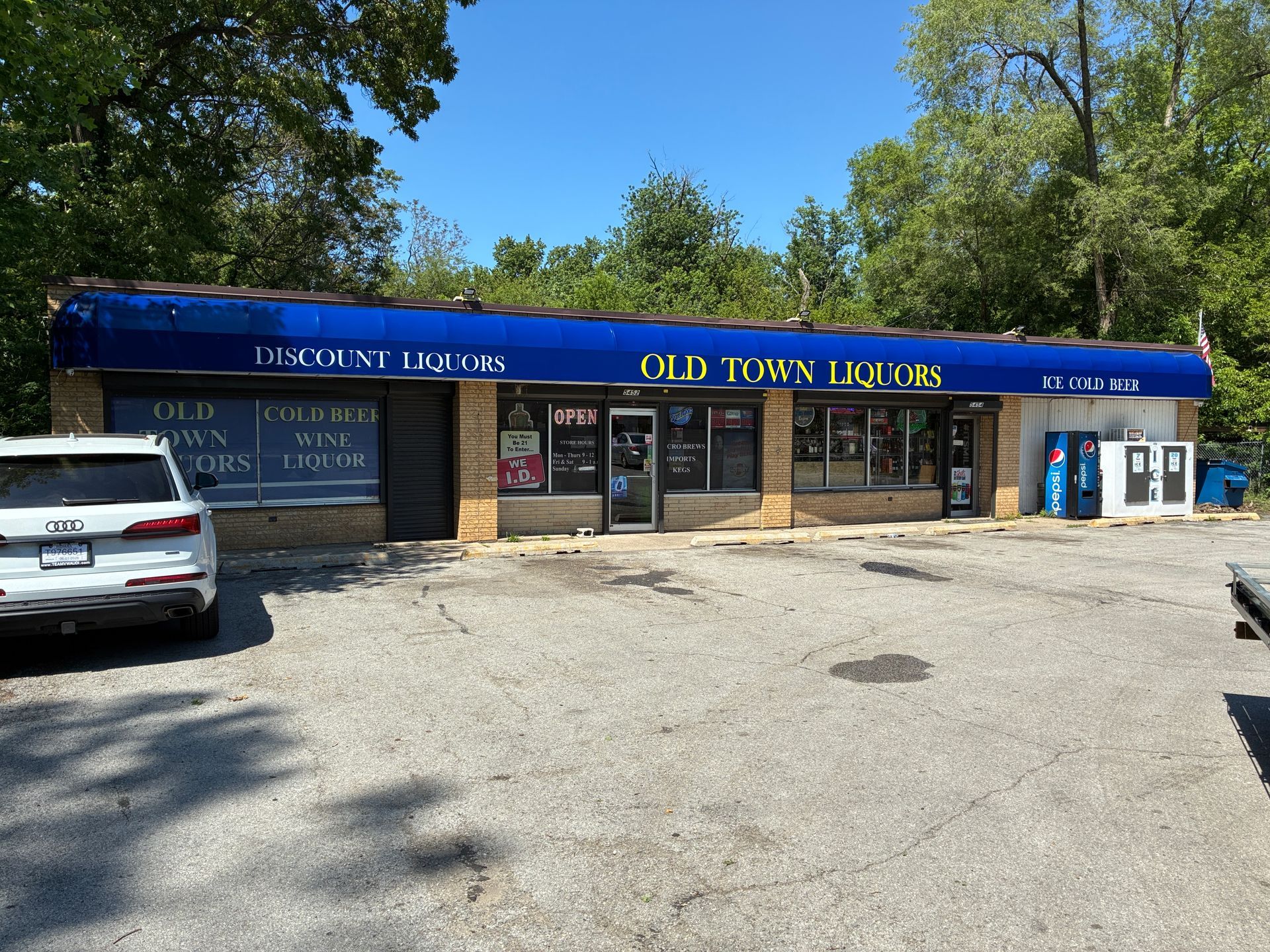 Small strip mall storefront labeled “Old Town Billiards,” with parking lot and parked cars under blue awning